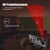 A digital alarm clock projecting the time onto a ceiling in a dimly lit room, with a sofa in the foreground. Produktbild-Vorschau
