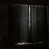 A dimly lit room with sheer curtains featuring cut-out stars, allowing light to filter through. Voir les images du produit