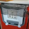 A close-up of a foldable trash can with instructions on it, placed inside a larger red container. Náhľad obrázku produktu
