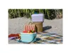 Two Polarbox coolers are displayed on a beach blanket with fruit and other picnic items. Podgląd zdjęcia produktu