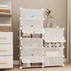 A white modular shoe rack with multiple compartments, some open and displaying folded clothes and other items, next to a white dresser. Produktbild-Vorschau