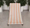 A striped beach chair is shown in a room with potted plants in the background. Podgląd zdjęcia produktu