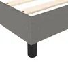 Close-up of a bed frame corner with dark gray fabric upholstery and wooden slats. Voir les images du produit