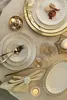 A beautifully set table with porcelain plates, cutlery, and decorative elements. Produktbild-Vorschau