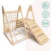 A wooden indoor playground structure with a slide, climbing net, and ladder. Produktbild-Vorschau