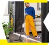 A woman is cleaning the floor with a steam cleaner in a modern kitchen. Voir les images du produit