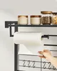 A hand pulls a sheet of paper towel from a roll mounted on a kitchen organizer rack. Produktbild-Vorschau