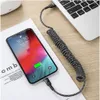 A coiled charging cable connects a smartphone to a laptop. Anteprima dell’immagine prodotto