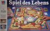 The image shows the box of the board game "Spiel des Lebens" (The Game of Life). The board game itself is visible on the box, along with some of its components like money and game pieces. A hand is shown interacting with the game. Produktbild-Vorschau