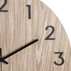 A close-up view of a wooden clock face with black hour markers and hands. Anteprima dell’immagine prodotto