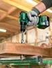 A person wearing a glove is using a cordless drill to drill into a wooden beam in a workshop. Produktbild-Vorschau