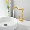 A golden faucet with water running into a white sink, next to a vase of calla lilies. Podgląd zdjęcia produktu