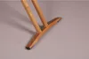 A close-up shot of the wooden base and legs of an ironing board. Produktbild-Vorschau