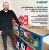 A man stands next to a shelving unit filled with various items, including boxes and tools. Anteprima dell’immagine prodotto