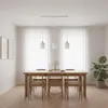 A dining room setting with a wooden table and chairs, illuminated by a modern pendant light fixture. Náhľad obrázku produktu