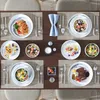 A table setting with multiple plates of food and cutlery, suggesting a meal. Produktbild-Vorschau