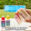 A person is holding test tubes over a table with two bottles of pool testing solution, with a pool in the background. Produktbild-Vorschau