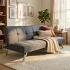 A living room scene with a sofa, bookshelf, and window. Voir les images du produit