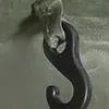 A close-up shot of a black metal hook attached to a gray surface. Anteprima dell’immagine prodotto