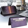 A smartphone case is shown in two configurations: one as a stand for a phone, and the other open to reveal card slots. The background suggests a desk setting with a laptop and other office items. Produktbild-Vorschau