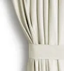 A close-up view of a cream-colored velvet curtain with pleats and a decorative band. Podgląd zdjęcia produktu