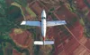 Aerial view of a small airplane flying over agricultural fields. Anteprima dell’immagine prodotto