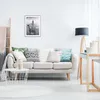 A living room scene with a sofa, coffee table, and a desk. Produktbild-Vorschau