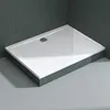 A rectangular shower tray with a textured surface and a drain, set against a dark tiled wall and light gray floor. Produktbild-Vorschau