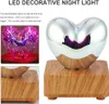 A heart-shaped decorative night light with a wooden base, shown with and without illumination. Produktbild-Vorschau