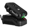 A black battery pack is placed on a black battery charger. The battery pack has green and red indicator lights. Podgląd zdjęcia produktu