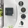 A dark gray mailbox with an owl design is mounted on a light gray textured wall, next to a black metal fence. There are inset circles with text and images highlighting features of the mailbox. Produktbild-Vorschau