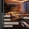 A living room scene with a floor lamp and a remote control, showcasing lighting features. Náhled obrázku produktu