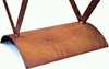 A close-up view of a curved metal shelf with a rustic, weathered finish, supported by two V-shaped metal legs. Produktbild-Vorschau