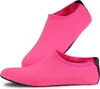 Paar leuchtend pinke Wasserschuhe mit schwarzen Sohlen, einer aufrecht stehend und einer flach liegend