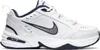 A white Nike Air Monarch IV sneaker with navy blue and gray accents, shown from the side against a white background. Anteprima dell’immagine prodotto