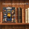 A miniature bookshop diorama placed on a wooden shelf, surrounded by large, decorative books. Náhled obrázku produktu