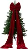 A large red velvet bow is placed on top of a green Christmas tree. Podgląd zdjęcia produktu