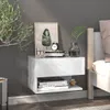 A white floating nightstand with books and decor next to a bed. Produktbild-Vorschau