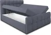A grey upholstered bed frame with the storage compartment open, revealing a white interior. Produktbild-Vorschau