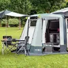 A camping tent attached to a van, with a table and chairs set up outside. Produktbild-Vorschau