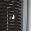 A close-up view of dark, glossy horizontal blinds with pull cords and plastic end caps. Produktbild-Vorschau