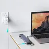 A docking station is connected to a laptop, and a power adapter is plugged into a wall socket. Produktbild-Vorschau