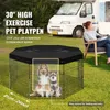 A dog playpen is set up on grass in front of a camper van, with a woman sitting in a chair nearby. Produktbild-Vorschau