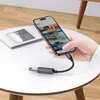 A hand holding a smartphone connected to an OTG adapter on a table. Náhľad obrázku produktu