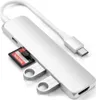 A silver USB-C hub with an SD card and two USB drives inserted, shown against a white background. Voir les images du produit