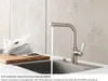 A kitchen sink with a faucet running water, a cutting board with vegetables, and a plastic bag. Anteprima dell’immagine prodotto