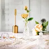 A still life arrangement of decorative items including flowers in a vase, a candlestick, and a glass bottle. Produktbild-Vorschau