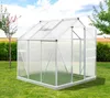 A greenhouse in a grassy yard with trees and fields in the background. Produktbild-Vorschau