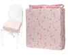 A clear product shot of a chair cushion and a wrapped gift box, both with a floral pattern. Produktbild-Vorschau