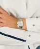A close-up shot of a woman's wrist wearing a silver watch. Náhled obrázku produktu
